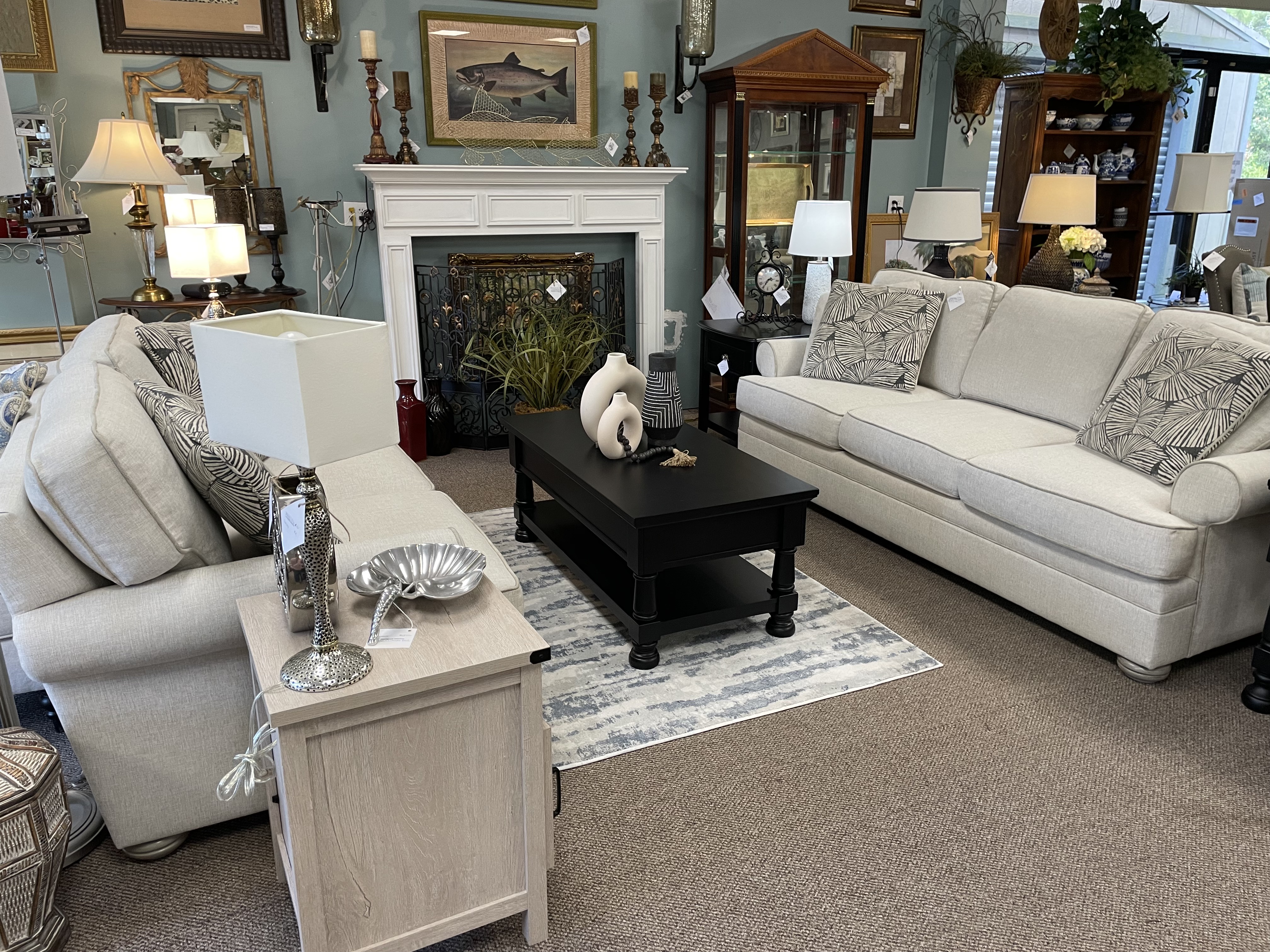 Two white couches with deep cushions facing each other with a cofee table on a rug between them.