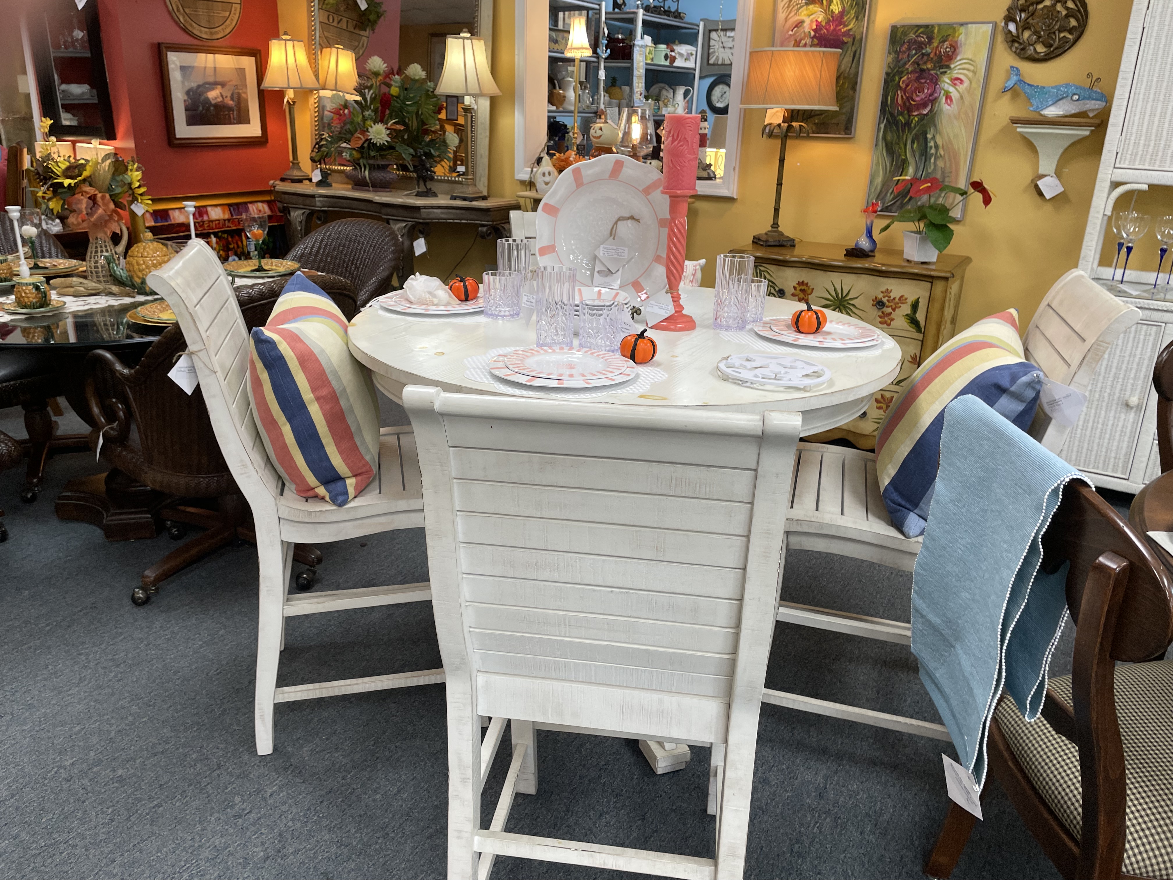 white round wooden 4-person table and chairs with place settings