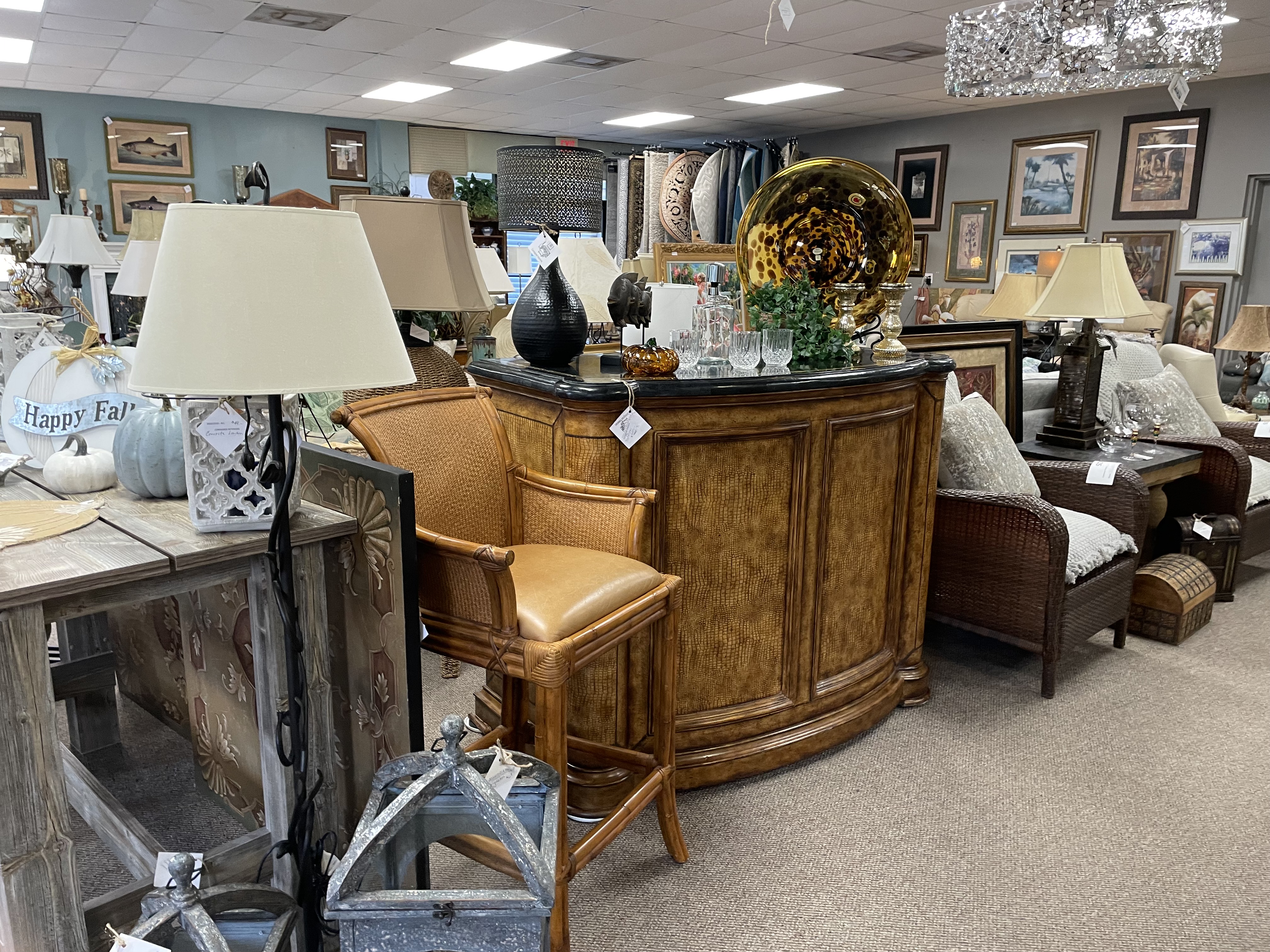 Wooden stand-alone bar cabinet with marble top and other home accessories like chairs, tables and lamps 
